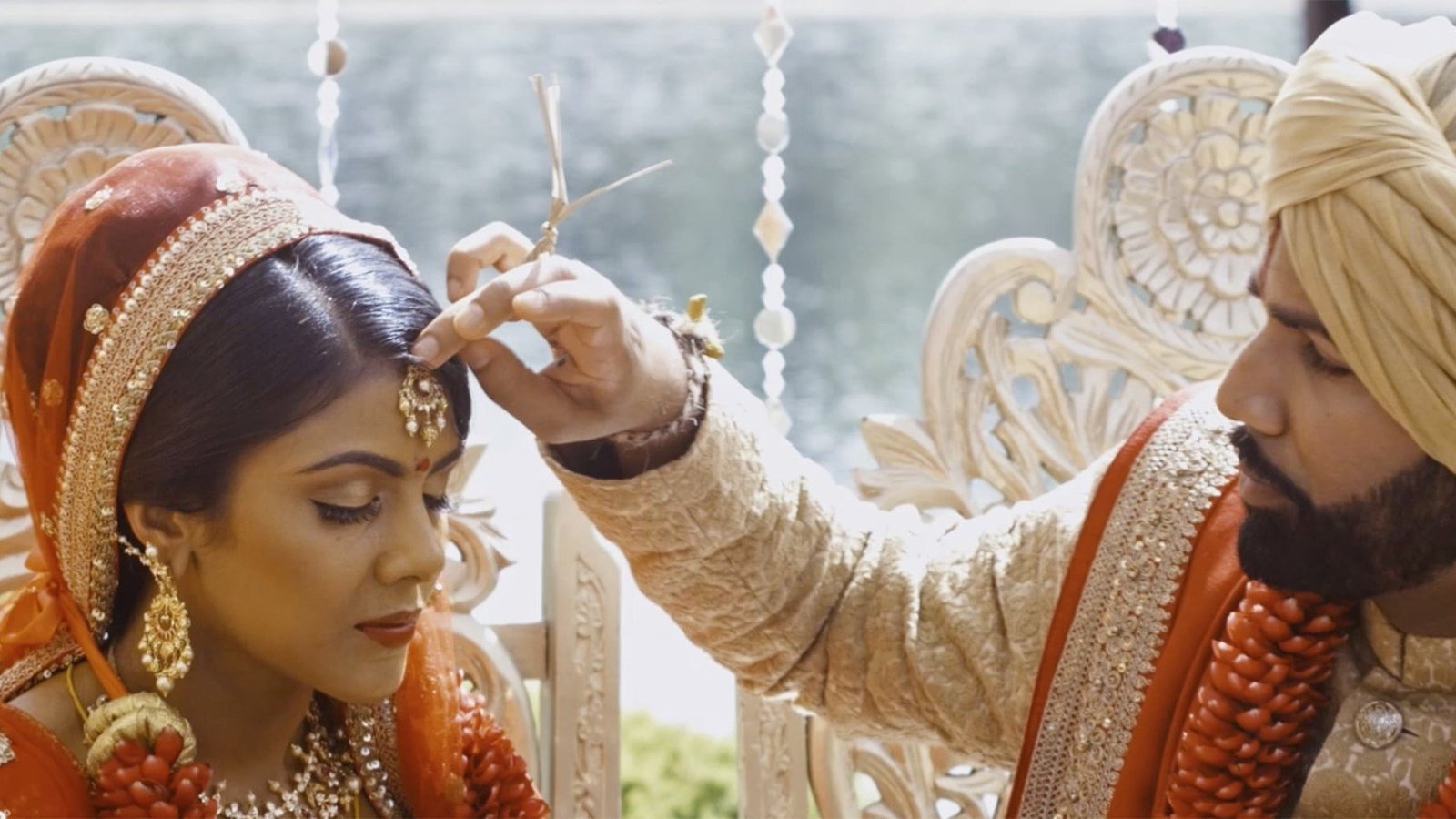 Cinematic wedding film close-up of Roger placing jewellery on Samantha during their ceremony