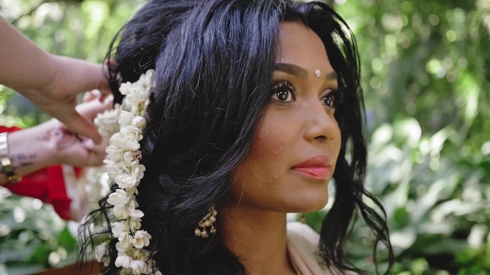 Destination wedding film still of a bride having jasmine placed in her hair