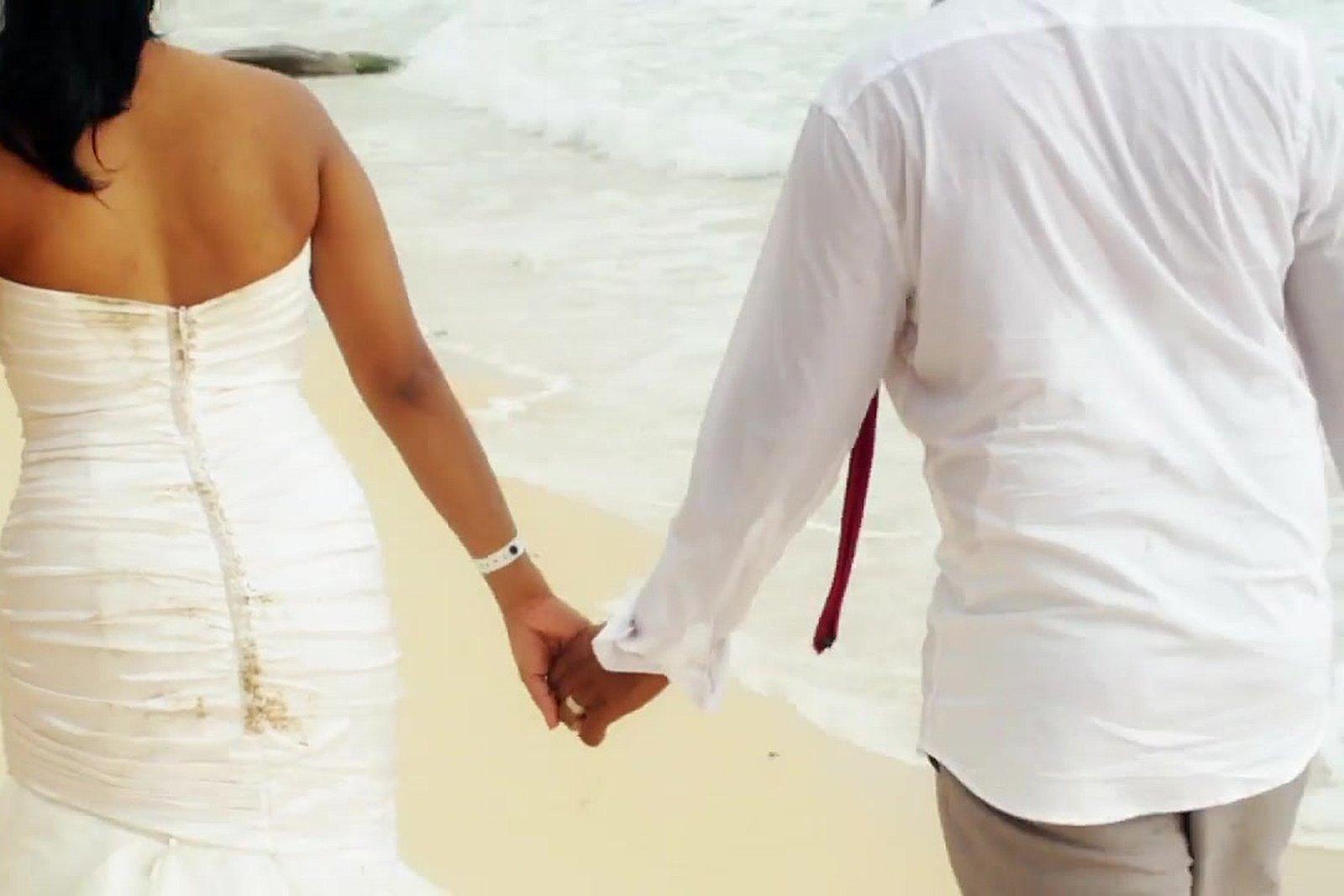 Punta Cana destination wedding: the bride and groom walking hand in hand along the beach, from our wedding film Fiona + Ricky