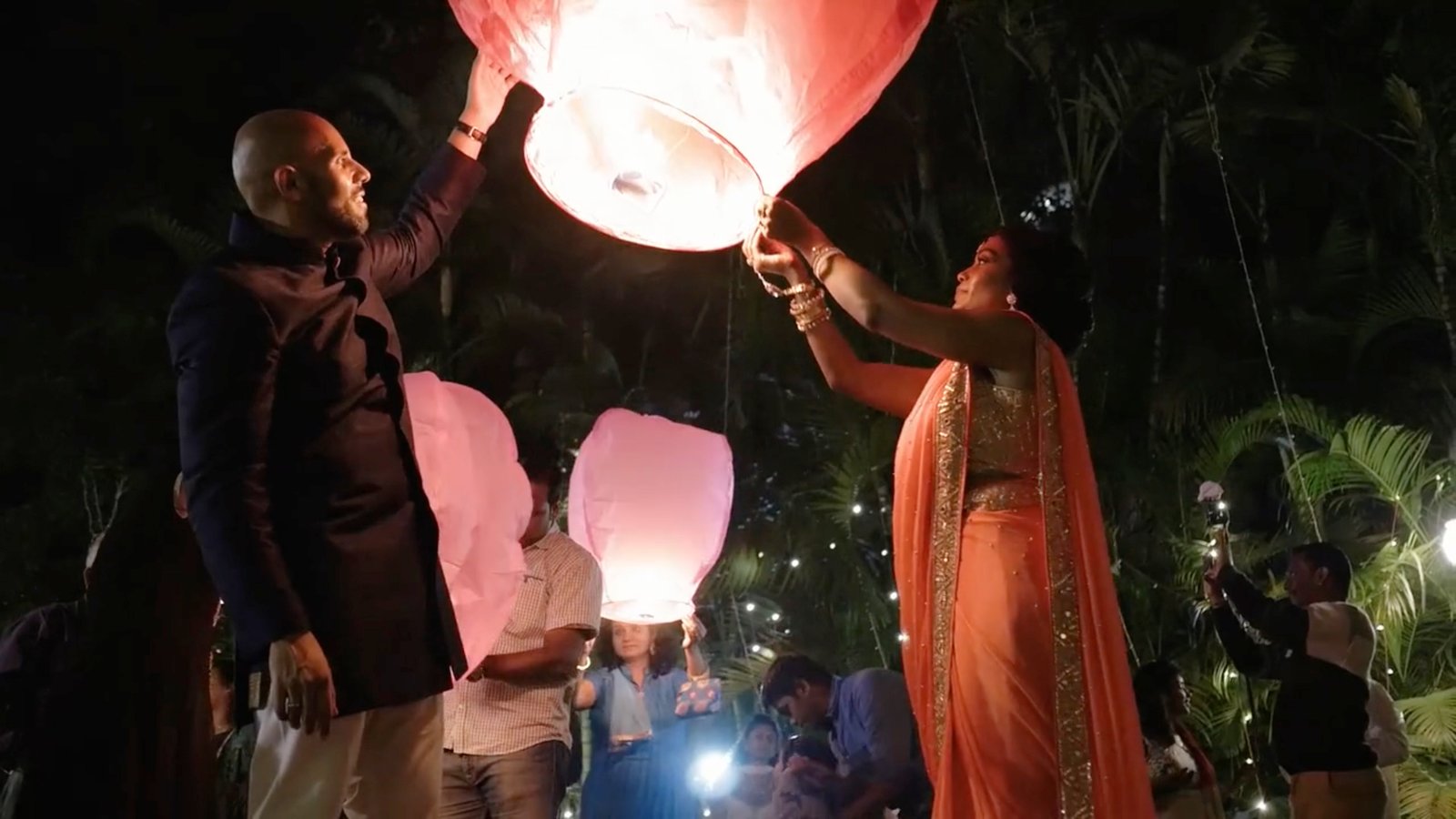 Shobana and Michael release a glowing lantern at night