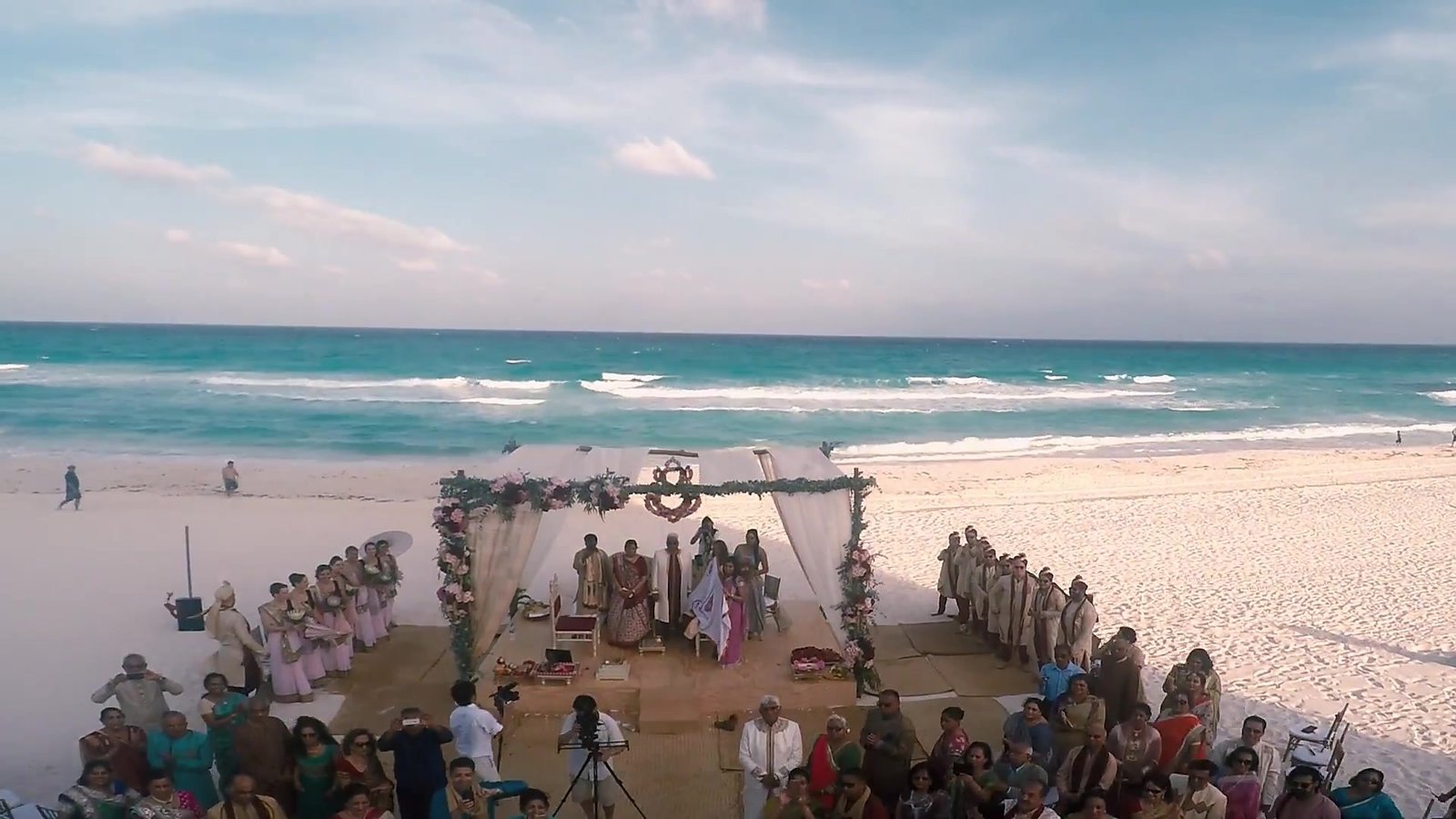 Zanzibar destination wedding inspiration: guests gathered for an oceanfront beach ceremony, from Anisha and Kushal's destination wedding film